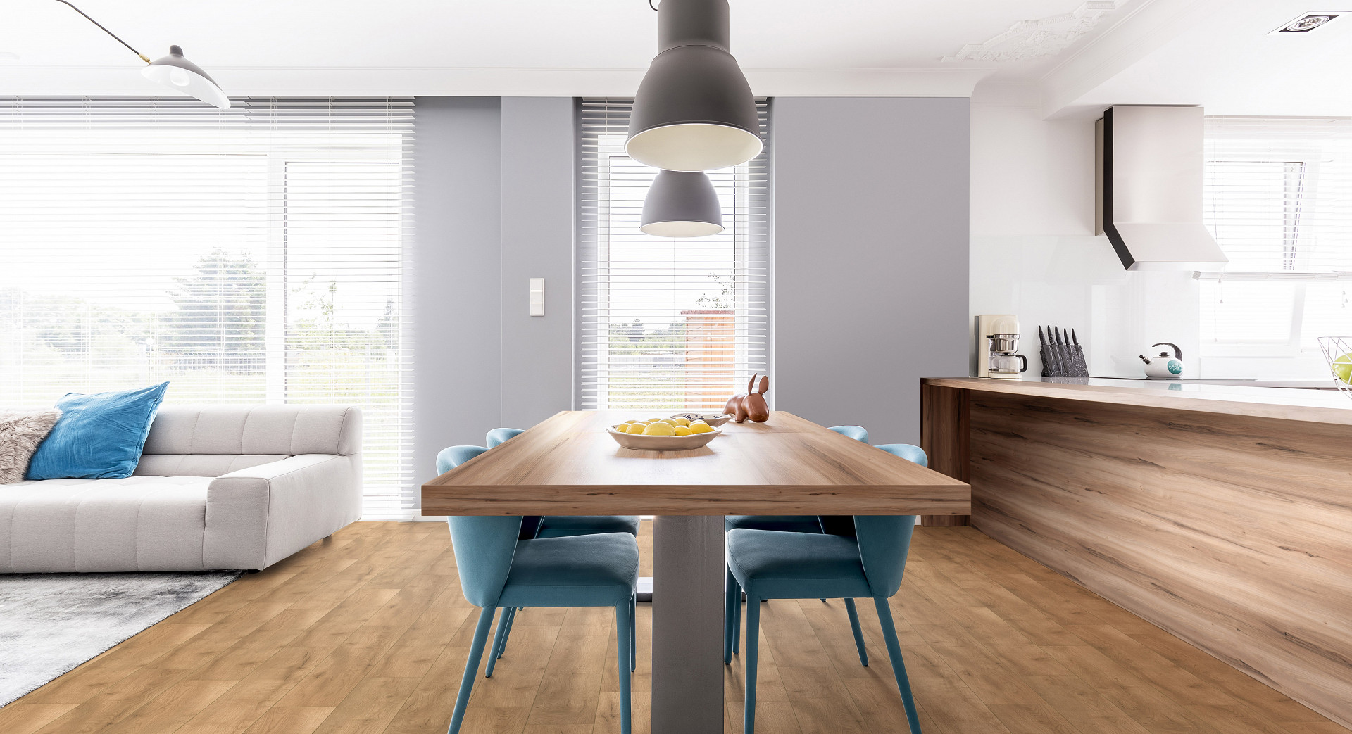 A Spc Flooring Z209 Butterscotch oak dining room table with blue chairs and a white couch.