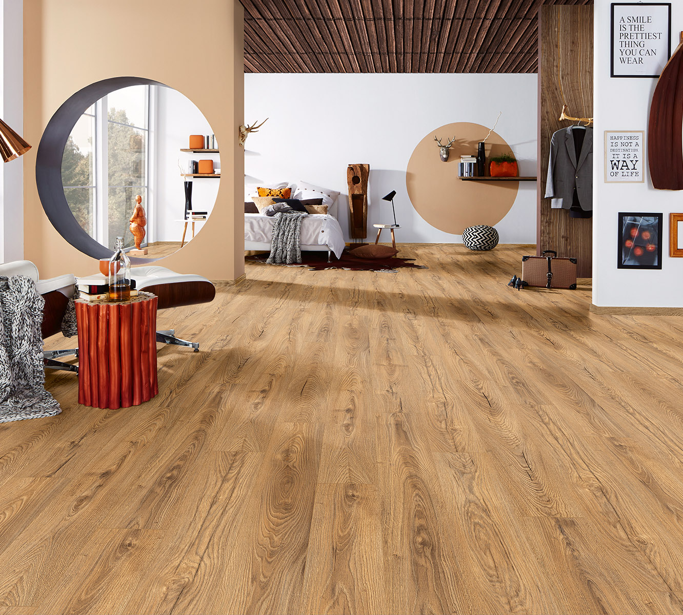 Inca Carpenter Oak 12 mm laminate flooring in open-plan space with visible bedroom and dining zones – unifying rustic elegance
