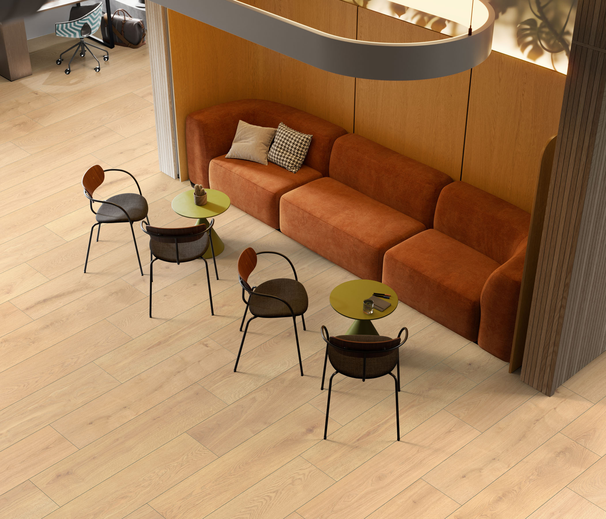 R172 Vigra Oak flooring in a spacious public area with tables and an orange sofa, adding natural warmth and style with its realistic woodgrain and wide planks.