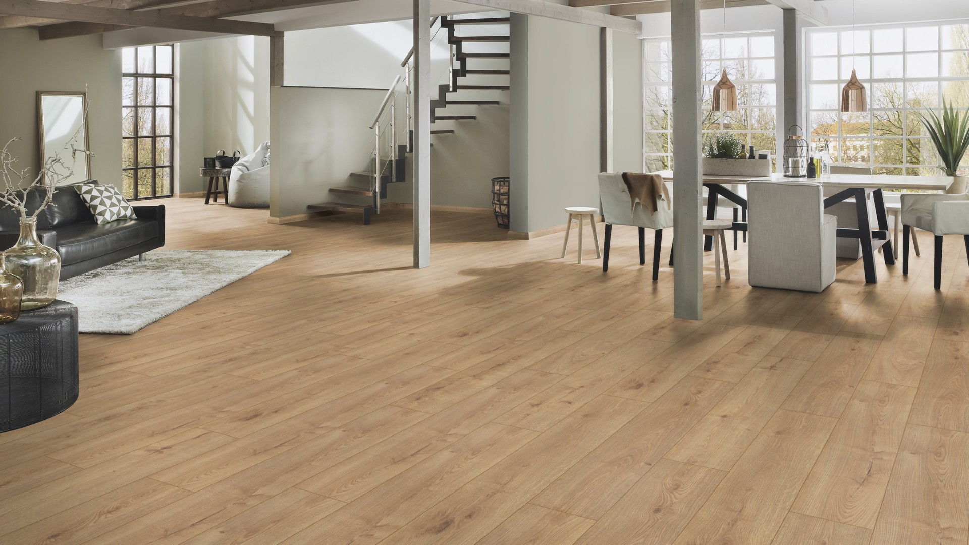 Sundance Oak laminate covering full living space – inviting oak tones unifying a spacious modern interior with stairs