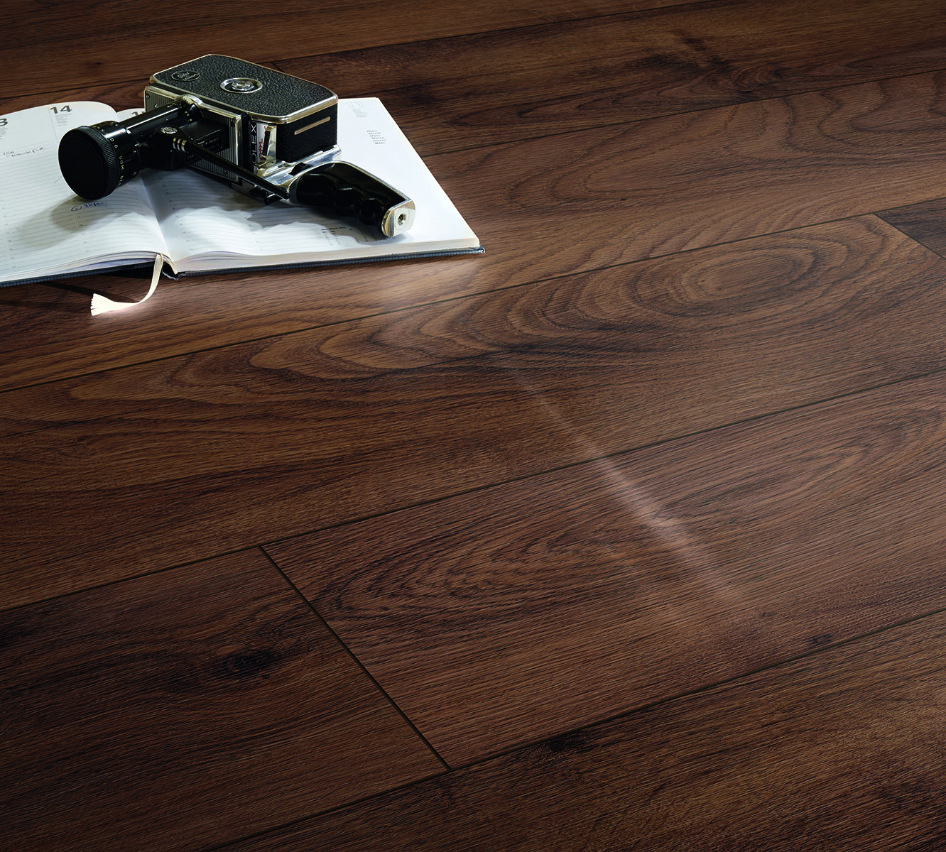Natural oak texture of K505 Tobacco Manor Oak laminate flooring with authentic texture and V-groove, styled with magazine and camera