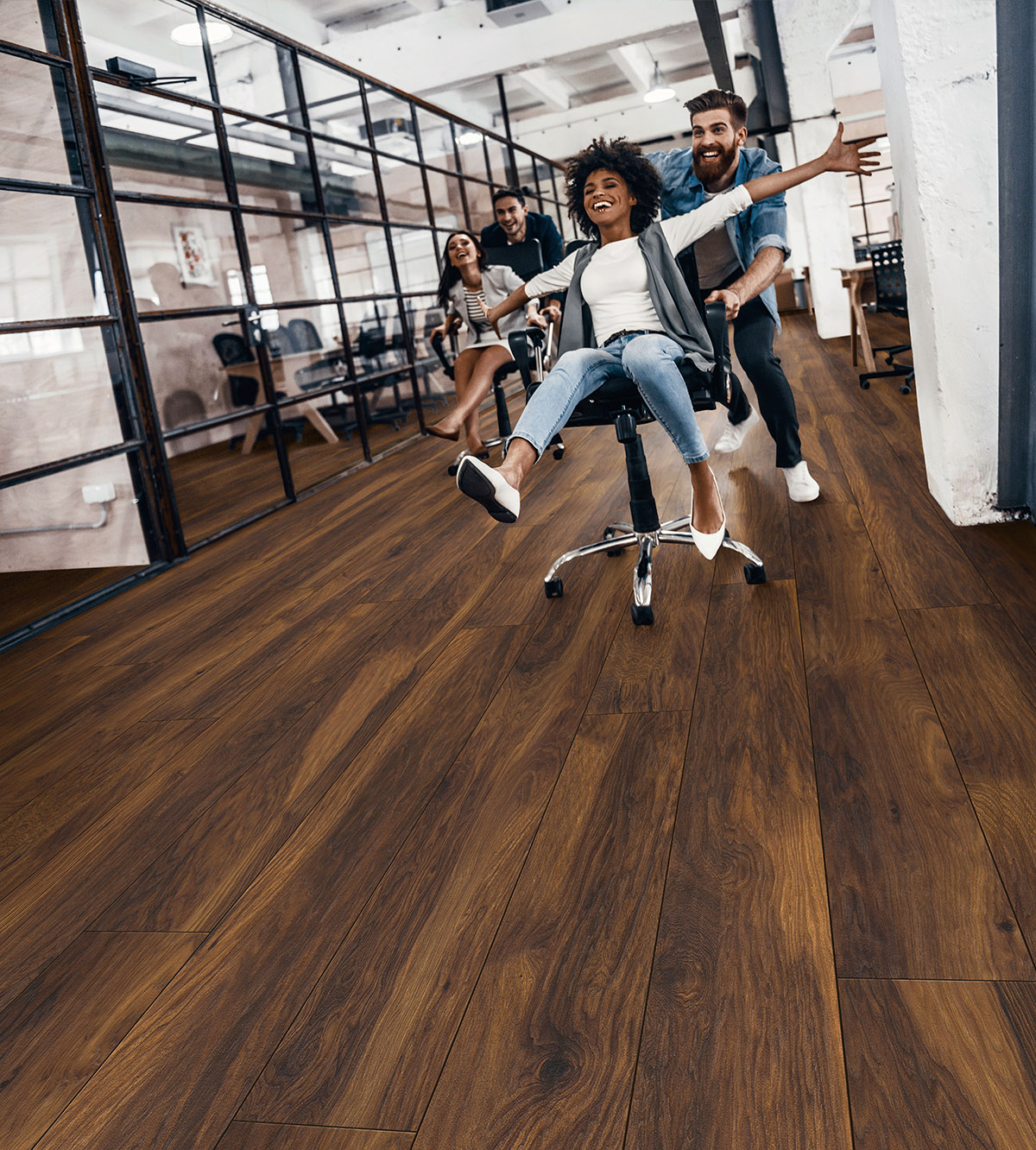 8156 Red River Hickory flooring in a busy office with employees rolling chairs – demonstrating scratch-resistant durability