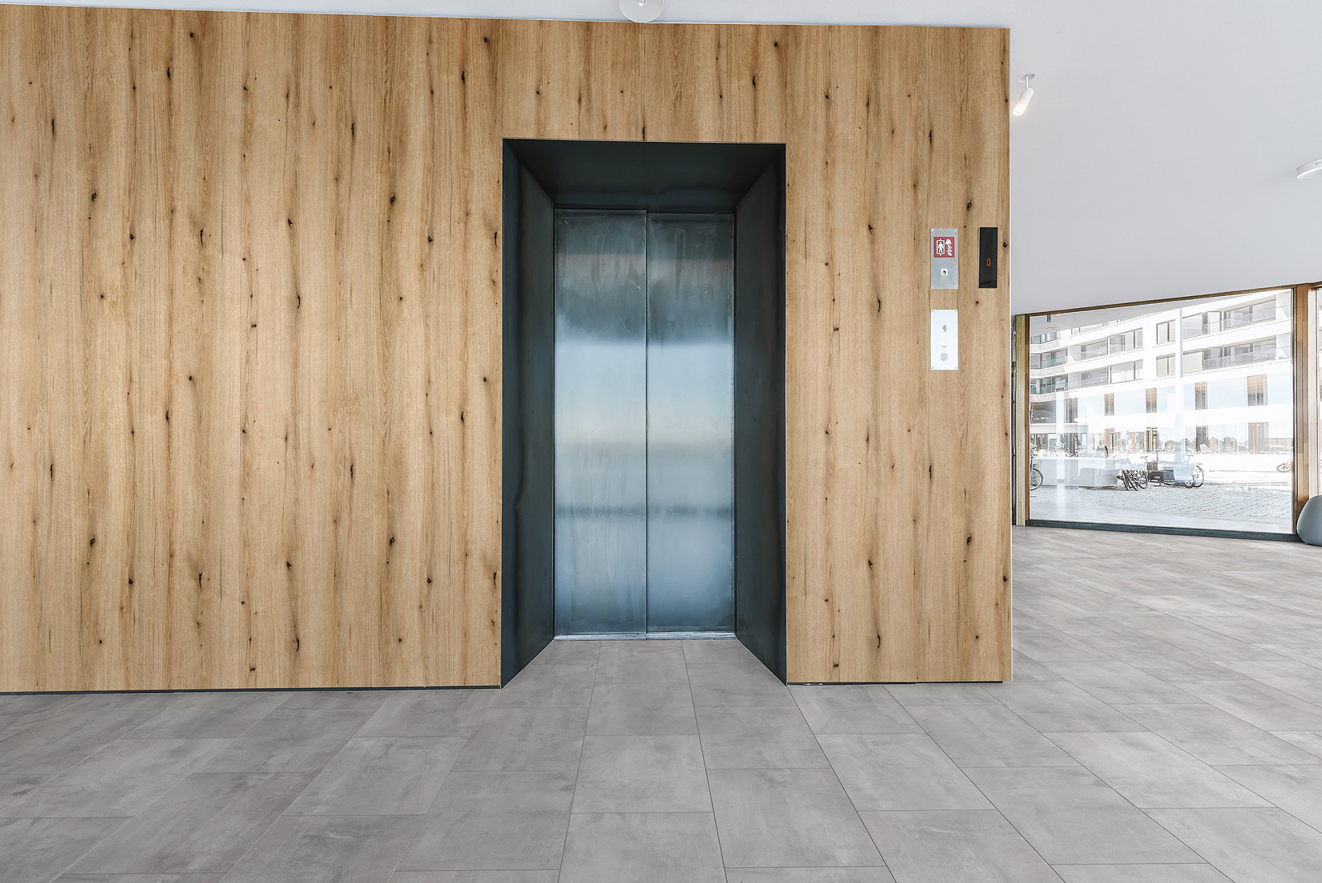 Coast Evoke Oak SPC wall panel from Rocko Tiles collection installed around elevator – modern wood-look solution for commercial interiors