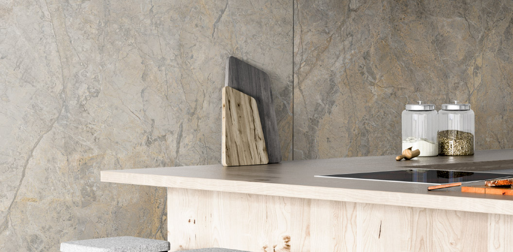 Modern kitchen countertop with wooden cutting boards and glass jars against a marble-effect backdrop