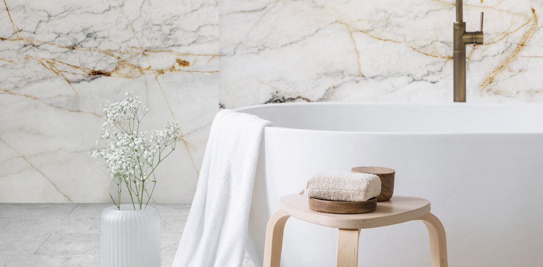 Luxury bathroom with marble walls, round bathtub, and decorations with flowers and towels